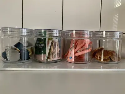 a shelf filled with jars of food and bread at Canal Studio Apartment in Amsterdam