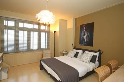 a bedroom with a large bed and a chandelier at Canal Studio Apartment in Amsterdam