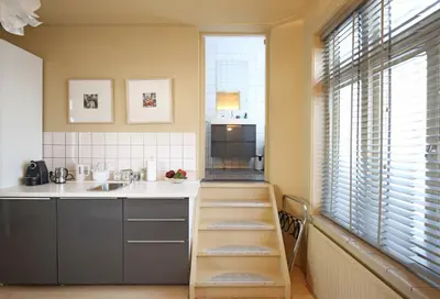 a kitchen with a sink and a counter with a shelf at Canal Studio Apartment in Amsterdam