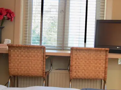 two chairs sitting in front of a desk with a television at Canal Studio Apartment in Amsterdam