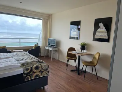 a bedroom with a bed and a table with a laptop at Studio Coastview in Zandvoort