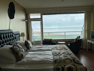 a bedroom with a large bed with a view of the ocean at Studio Coastview in Zandvoort