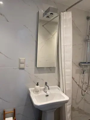 a white bathroom with a sink and a mirror at Studio Coastview in Zandvoort