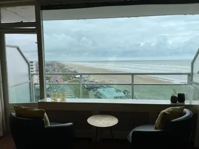 a view of a beach from a restaurant with chairs and a table at Studio Coastview in Zandvoort
