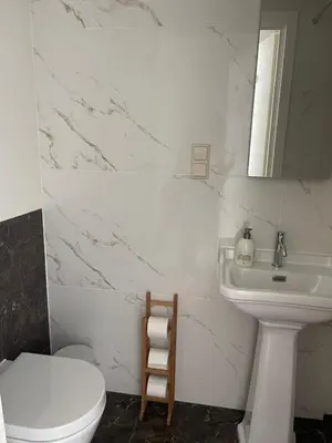 a white bathroom with a sink and a toilet at Studio Coastview in Zandvoort