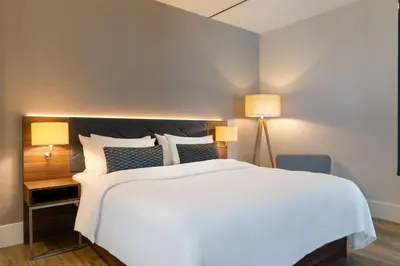 a bedroom with a large white bed and two lamps at Element Amsterdam in Amsterdam