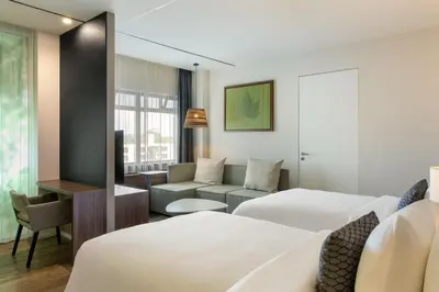 a hotel room with two beds and a couch at Element Amsterdam in Amsterdam