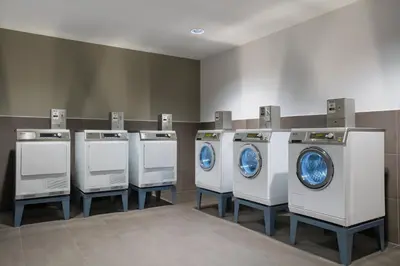 a row of white washing machines in a laundry room at Element Amsterdam in Amsterdam