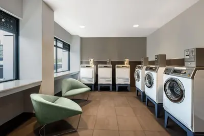 a laundry room with a row of washers and dryers at Element Amsterdam in Amsterdam