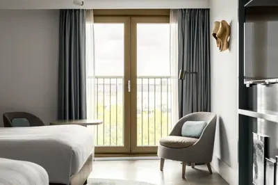 a hotel room with a bed and a chair and a window at Amsterdam Marriott Hotel in Amsterdam