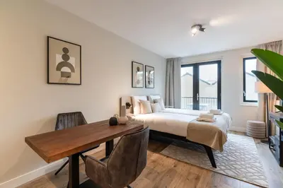 a bedroom with a bed and a wooden table at UtrechtCityApartments – Weerdsingel in Utrecht
