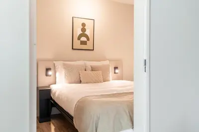 a bedroom with a bed with white sheets and pillows at UtrechtCityApartments – Weerdsingel in Utrecht