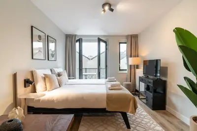 a bedroom with a large bed and a tv at UtrechtCityApartments – Weerdsingel in Utrecht