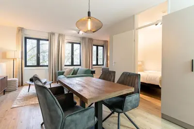 a living room with a dining room table and chairs at UtrechtCityApartments – Weerdsingel in Utrecht