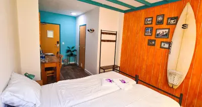 a bedroom with a bed and surfboards on the wall at The Flying Pig Beach Hostel Age 18 to 40 in Noordwijk aan Zee