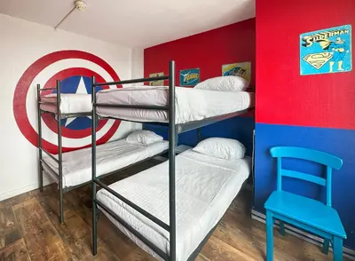 a bunk room with two bunk beds and a target at The Flying Pig Beach Hostel Age 18 to 40 in Noordwijk aan Zee