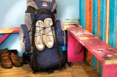 a bag with shoes in it next to a bench at The Flying Pig Beach Hostel Age 18 to 40 in Noordwijk aan Zee
