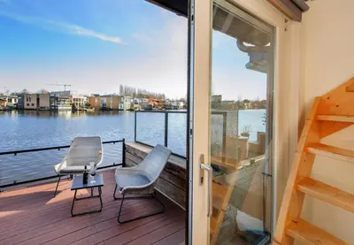 a balcony with a view of the water at Houseboat studio with canalview and free bikes in Amsterdam