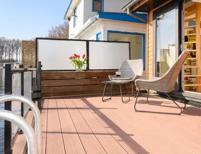 a patio with chairs and a screen on a house at Houseboat studio with canalview and free bikes in Amsterdam