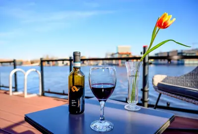 a bottle of wine sitting on a table with a glass at Houseboat studio with canalview and free bikes in Amsterdam