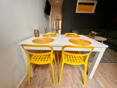 a table with yellow chairs and a white table with a yellow table at Zandvoort Station Apartment in Zandvoort