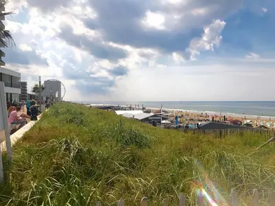 a view of a beach with people sitting on a hill at Zandvoort Station Apartment in Zandvoort