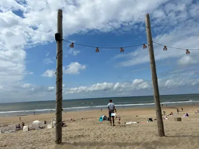 a man standing on the beach looking at the ocean at Holiday Home Stern Comfort-1 by Interhome in Noordwijk