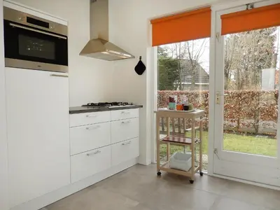 a kitchen with white cabinets and a window at Holiday Home Stern Comfort-1 by Interhome in Noordwijk