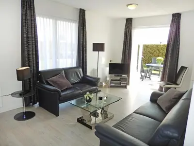 a living room with a leather couch and a table at Holiday Home Plevier Comfort-1 by Interhome in Noordwijk