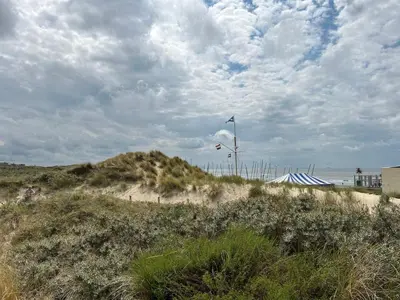 a sandy beach with a flag on top of it at Holiday Home Plevier Comfort-1 by Interhome in Noordwijk