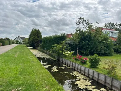 a river with plants and flowers in a yard at Holiday Home Plevier Comfort-1 by Interhome in Noordwijk