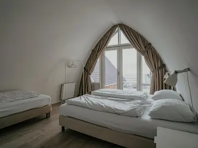 a bedroom with two beds and a large window at Holiday Home De Zeeparel by Interhome in Egmond aan Zee