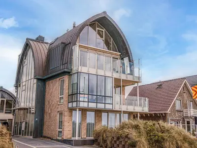an external view of a building with a large window at Apartment De Zeeparel by Interhome in Egmond aan Zee