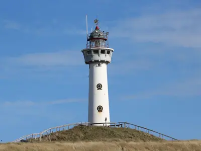 a white lighthouse on top of a hill at Apartment De Zeeparel by Interhome in Egmond aan Zee