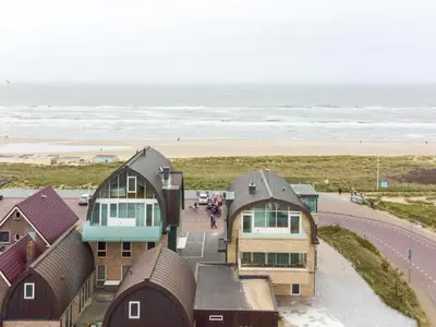 a group of houses on the beach with the ocean at Apartment De Zeeparel by Interhome in Egmond aan Zee