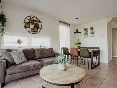 a living room with a couch and a table at Holiday Home Busch en Dam by Interhome in Uitgeest