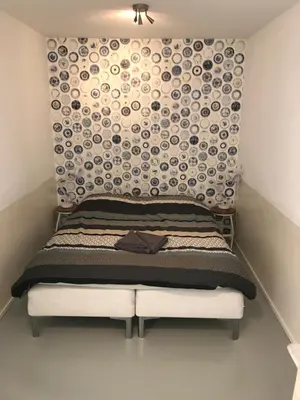 a bed in a room with a wall filled with plates at Bed of Roses in Amsterdam