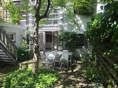 a patio with a table and chairs in front of a building at Bed of Roses in Amsterdam
