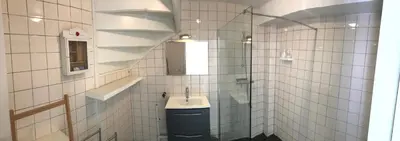 a white tiled bathroom with a sink and a mirror at Bed of Roses in Amsterdam