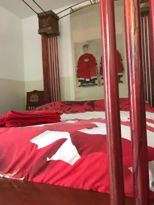 a bedroom with a bed with a red bedspread at Bed of Roses in Amsterdam