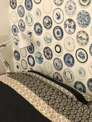 a wall full of blue and white plates on a wall at Bed of Roses in Amsterdam
