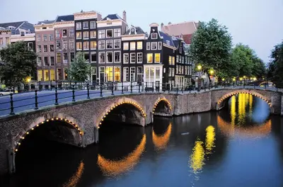a bridge over a river in a city with buildings at Bed of Roses in Amsterdam