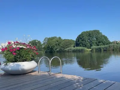 a large white bowl sitting on top of a dock next to a lake at Aan de Amstel in De Hoef