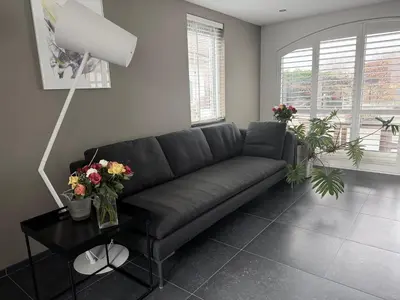 a living room with a couch and flowers on a table at Aan de Amstel in De Hoef
