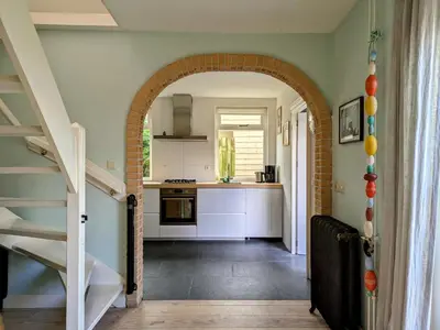 an archway leading into a kitchen with a staircase at Le-Clochard in Groet