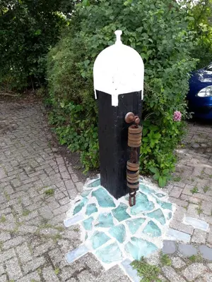 a black and white fire hydrant sitting on a sidewalk at Le-Clochard in Groet