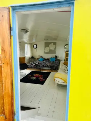 a view of a room with a bed and a living room at The Island Houseboat in Amsterdam