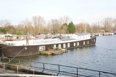 a large boat docked at a dock in the water at The Island Houseboat in Amsterdam