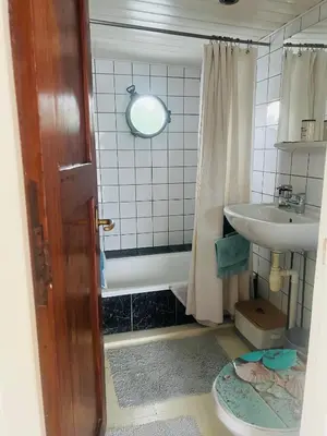 a bathroom with a tub and a sink and a mirror at The Island Houseboat in Amsterdam