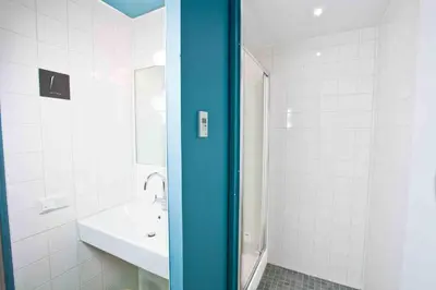 a white bathroom with a sink and a shower at Generator Amsterdam in Amsterdam